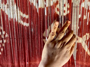 red ikat loom with weavers hand in Sumba Indonesia